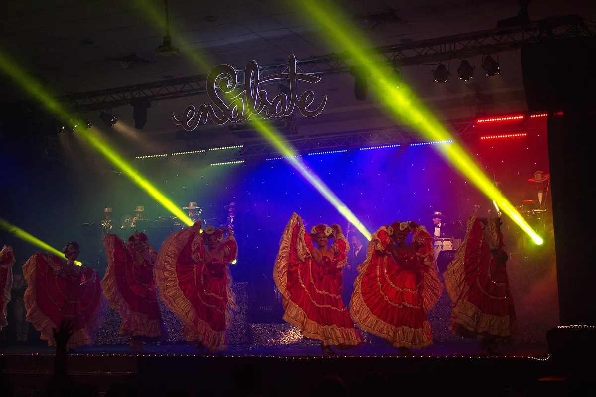 A salsa show on stage in Cali, Colombia, with dancers in red ruffled skirts