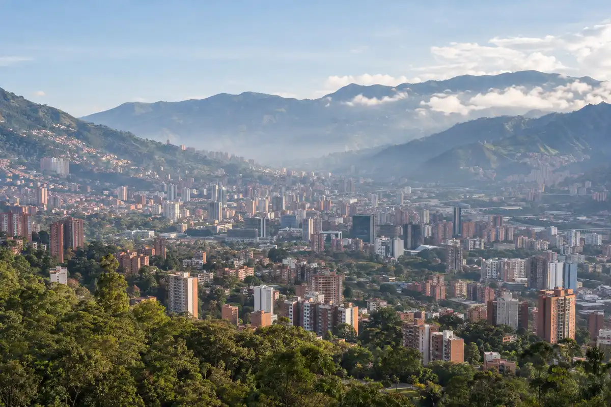 Illustration of Medellín across the green Aburrá Valley in morning haze