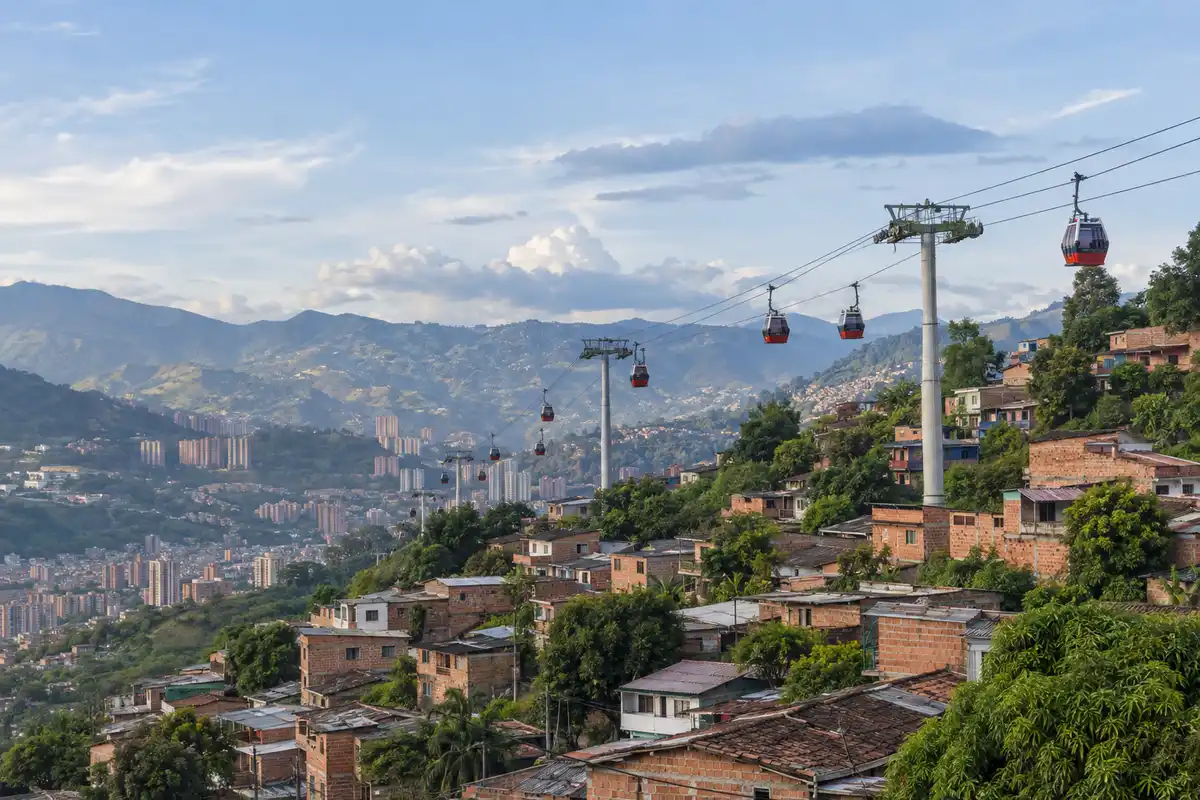 Illustration of cable cars above a brick hillside neighborhood in Medellín
